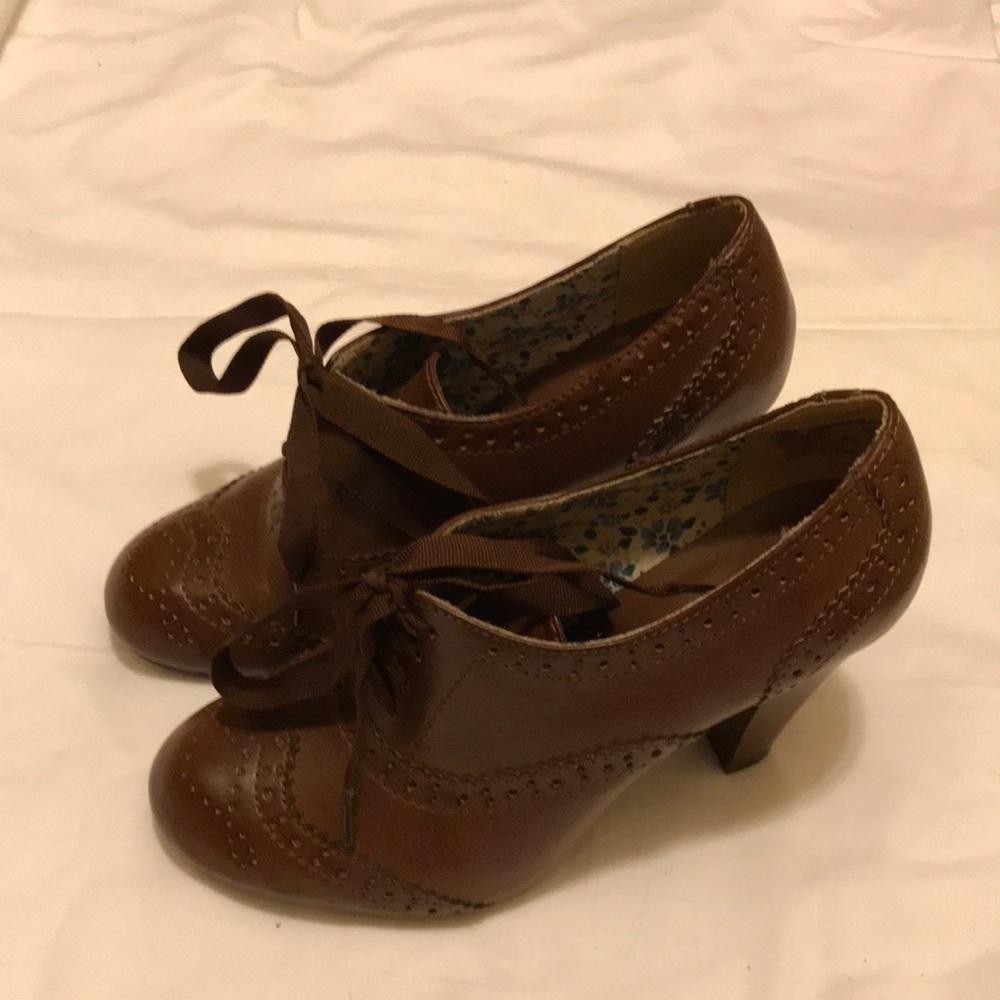 Dark brown heeled loafer style shoe.